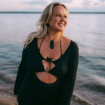 Woman in a black dress with stylish handmade jewellery standing by the water